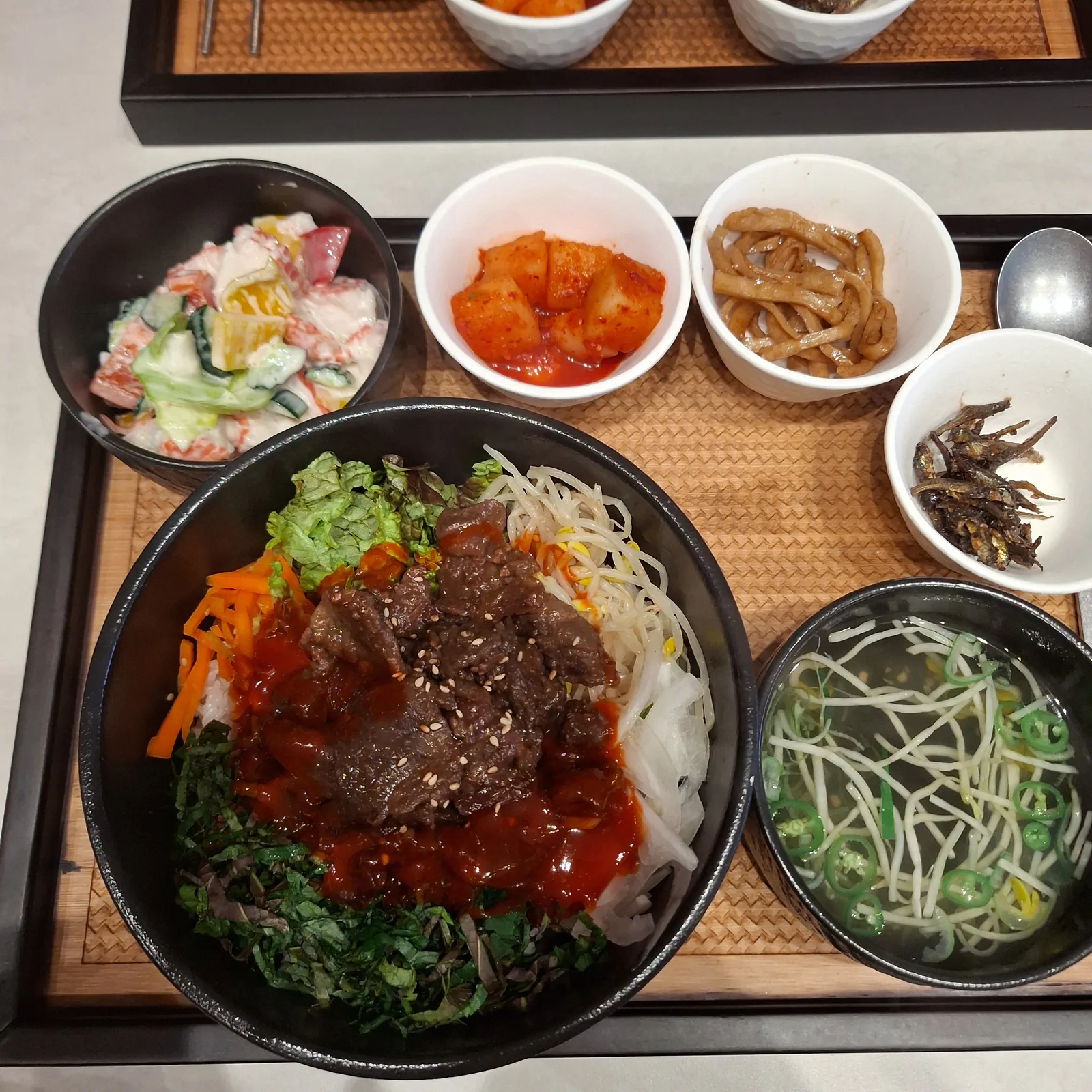 Bulgogi bibimbap with marinated beef, soup and side dishes