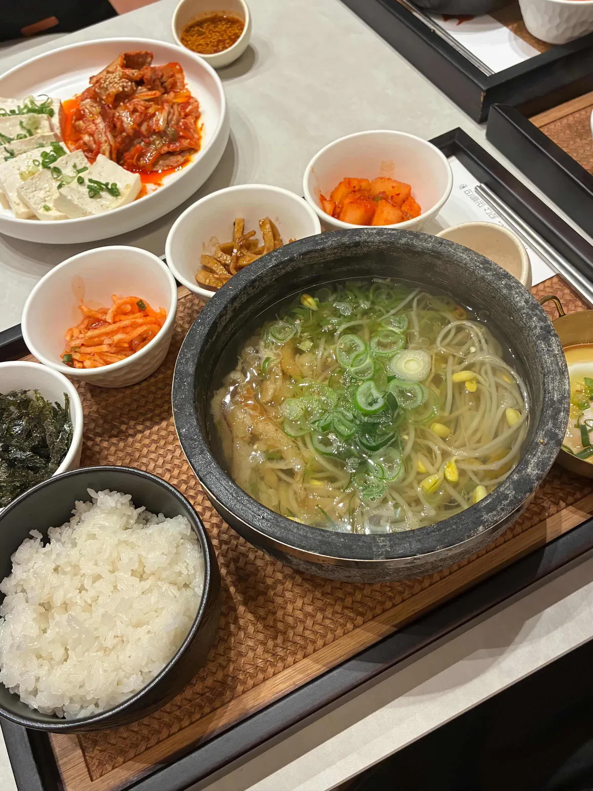 Hwangtae kongnamul gukbap in a stone pot with white rice and side dishes
