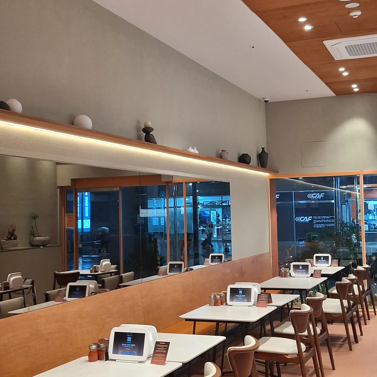Tables along the window wall under soft indirect lighting