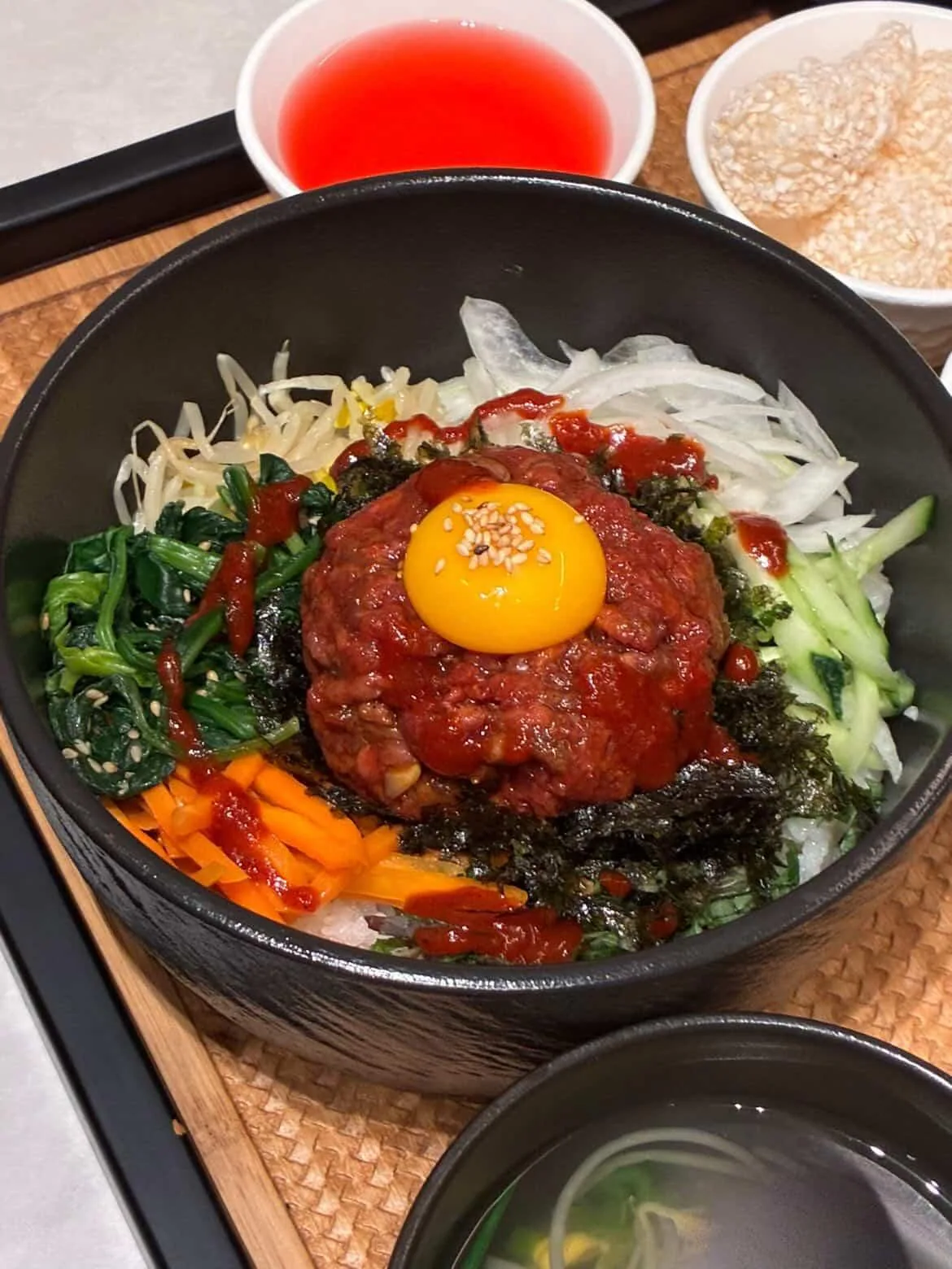 Hanwoo beef tartare bibimbap topped with an egg yolk